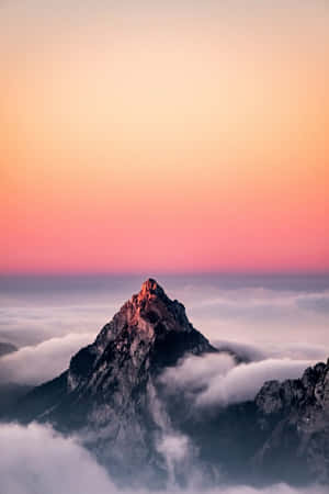 日出時分，山峰聳立於雲海之上，天空呈現粉紅色和橙色。 — Huawei MatePad 壁紙