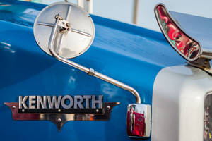 復古藍色 Kenworth 卡車的鍍鉻側鏡和標誌特寫。