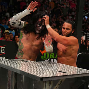 兩名摔角手在擠滿觀眾的場館內爭奪一張鋼桌。 — WWE GIF 壁紙