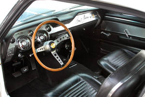 經典汽車內飾，配有黑色皮革座椅和木質方向盤。 — 悟空黑 iPhone 壁紙