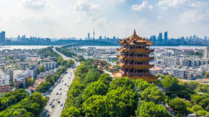 在有橋樑和天際線的現代城市中，坐落於綠樹之間的傳統寶塔。 — 天際線 壁紙