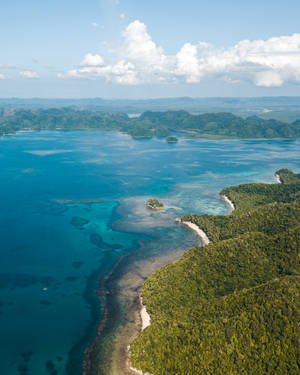 在藍天白雲下，碧綠潟湖和綠色島嶼的鳥瞰圖。 — 海灘度假 壁紙