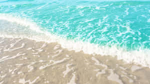 綠松石色的海浪沖刷著沙灘上的金色沙子。 — 海灘日落 壁紙