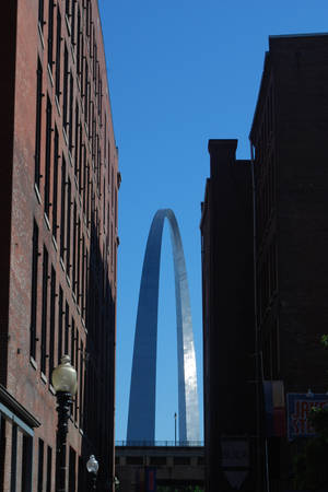 Gateway Arch 被磚砌建築物框住的日落景色 — 藍天 壁紙