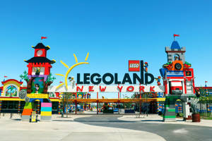 在晴朗藍天下，色彩繽紛的LEGO結構和大標誌的LEGOLAND New York入口。 — 紐約 壁紙