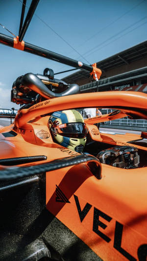 日落時分在巴塞隆納賽道上駕駛橙色麥拿侖賽車的F1車手。 — 賽車 壁紙