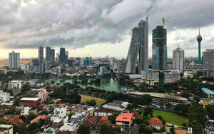 暴風雲下河流與摩天大樓的城市景觀。 — 斯里蘭卡 壁紙