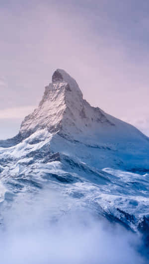 黎明時分，白雪覆蓋的馬特洪峰山頂聳立在雲層之上。 — 雪山 壁紙
