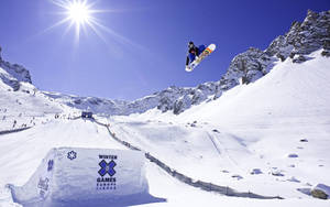 滑雪板運動員在歐洲冬季極限運動會雪坡上空中表演技巧。 — X Games 壁紙