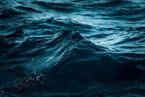 帶有紋理泡沫和戲劇性燈光的深藍色海浪。 — 海洋藍 壁紙