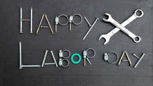 在深色背景上用金屬工具拼出的Happy Labor Day — 勞動節 壁紙