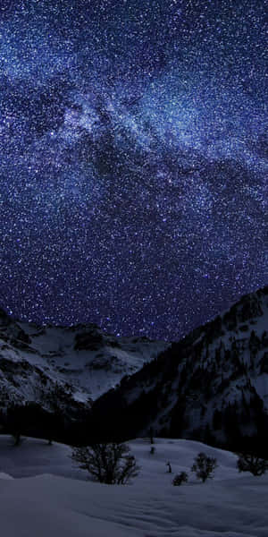 在繁星點點的夜空下，積雪的山峰和可見的銀河。 — 冬季美學 壁紙