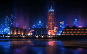 夜景城市天際線，發光的建築物倒映在河流中。 — 奇幻島 壁紙