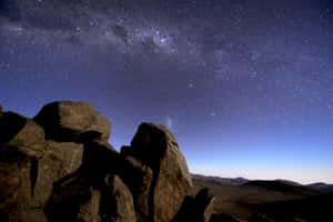 在可見銀河的星空夜空下的剪影岩石。 — 美學天空 壁紙