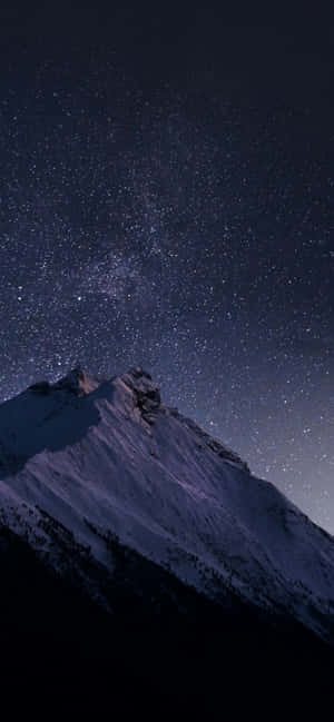 在可見銀河的星空下，積雪的山峰。 — 自然 iPhone 壁紙