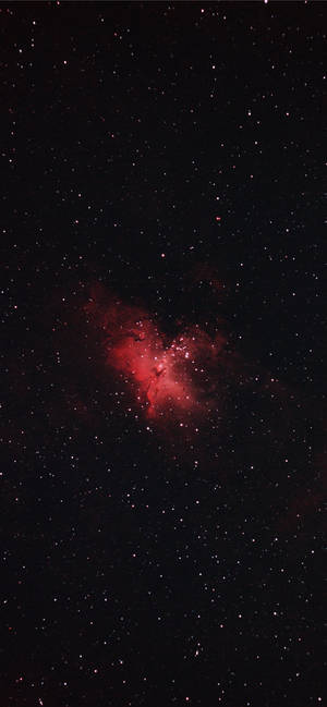 夜空中被無數星星環繞的發光紅色星雲。 — Pixel 8a 壁紙