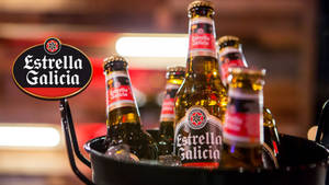 酒吧中冰桶內冰鎮的 Estrella Galicia 啤酒瓶。 — 暗色 壁紙