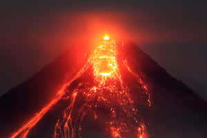 火山爆發，明亮的紅色熔岩在夜間沿著黑暗的山坡流下。 — 美麗的夜晚 壁紙
