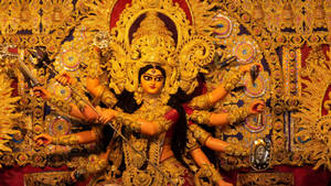 印度教女神杜爾迦的多臂持武器金色雕像。 — Maa Durga 壁紙
