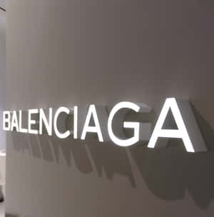 灰色牆壁上發光的 Balenciaga 標誌投下陰影。 — Pixel 10 Pro Fold 壁紙