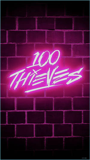 在黑暗的磚牆上，一個寫著 100 THIEVES 的粉紅色霓虹燈牌。 — 霓虹粉紅美學 壁紙