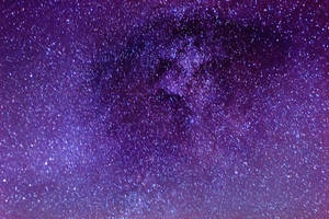 夜空中廣闊的紫色和藍色星場，帶有發光的宇宙塵埃雲。 — 最酷的桌面 壁紙