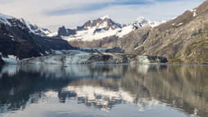 冰川在平靜的水面上倒映，背景是雪山。 — 山景 壁紙