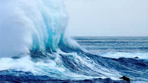 強大的海浪帶著白色泡沫沖擊著深色岩石。 — 波浪 壁紙