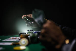 特寫鏡頭：在綠色毛氈桌上發撲克牌的手，旁邊有籌碼。 — 撲克牌桌 壁紙