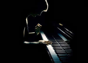 在燈光昏暗的房間裡，有人在聚光燈下彈鋼琴。 — 美學音樂 壁紙