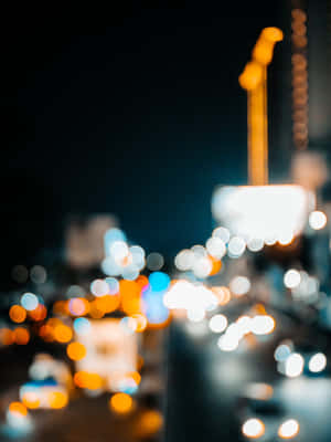 夜晚的城市燈光模糊成在黑暗街道上發光的光球。 — 2048x2732 壁紙