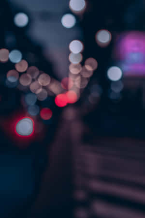 夜晚的城市燈光在黑暗的街道上模糊成發光的圓圈。 — 小米平板 8 Pro 壁紙
