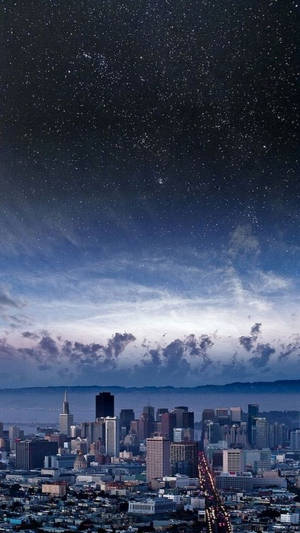 城市天際線，星空下，發光的街燈和縷縷雲彩。 — 城市風景 壁紙