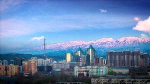 黃昏時分，城市天際線背景為白雪覆蓋的山脈。 — 城市風景 壁紙