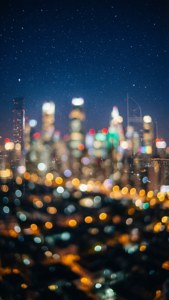 夜空下，城市燈光模糊成發光的光球。 — 夢幻 GIF 壁紙