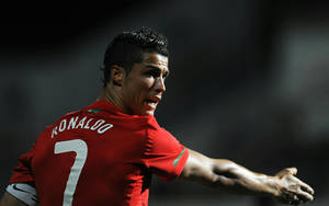 基斯坦奴·朗拿度身穿紅色葡萄牙7號球衣在球場燈光下慶祝。 — Cr7 壁紙