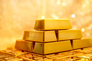 一堆閃閃發光的金條，帶有溫暖的散景背景。 — 金色動態 壁紙