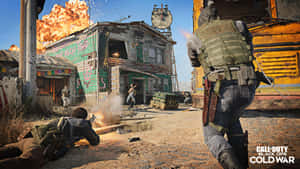 身穿戰鬥裝備的士兵在燃燒的沙漠小鎮中作戰。 — 決勝時刻黑色行動冷戰 壁紙