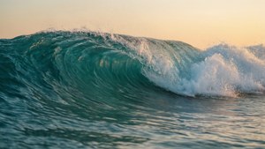 一個巨大的海浪在金色日落光芒中破碎。 — 超讚 壁紙
