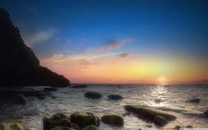 海洋上的夕陽，長滿苔蘚的岩石和懸崖剪影 — 拿坡里 壁紙