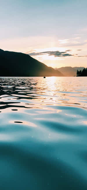 山間湖上的夕陽與平靜的水面倒影 — Pixel 9 Pro XL 壁紙