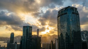 現代城市天際線的日落，有玻璃塔和遠山 — 香港 壁紙