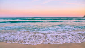 粉紅色和橙色的夕陽映照在海浪上，拍打沙灘，有衝浪者 — 日落 壁紙