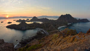 夕陽映照火山島，碧綠海水與蜿蜒海岸線。 — 海灘 壁紙