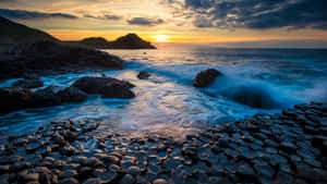 海洋上的日落，海浪拍打玄武岩層。 — 日落 壁紙