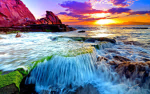夕陽下的海浪拍打著海邊長滿苔蘚的岩石。 — 海洋桌面 壁紙