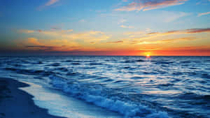 夕陽下的海洋，海浪沖刷沙灘 — 海灘日落 壁紙