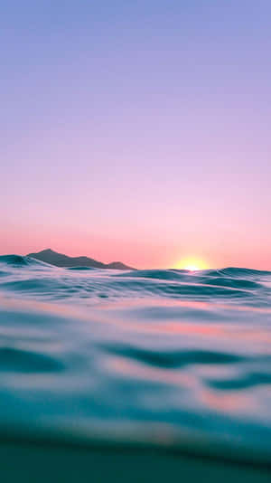 海洋上的日落，有山脈輪廓和寧靜的波浪 — 海洋 壁紙