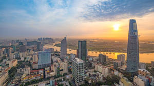 現代城市夕陽，高樓大廈與河流 — 胡志明市 壁紙