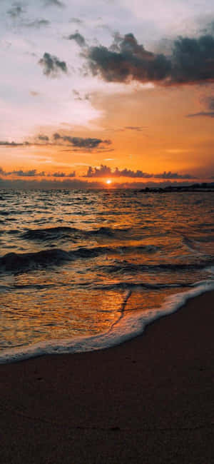 海洋上的夕陽與沙灘上的海浪 — iPhone 16 Pro Max 壁紙